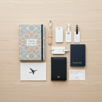 Assortment of thoughtful and practical travel gifts for a couple, including a travel journal, personalized luggage tags, and a gift card for experiences